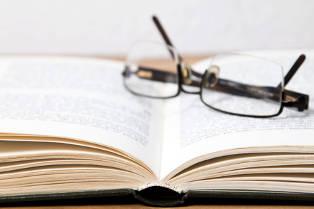 Glasses on open bookの写真素材