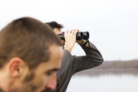 Men in boat on the river, monitoring with binoculars, adventure, realの写真素材