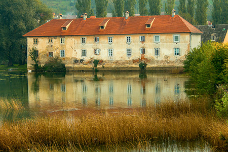 Old ruined rusty castle on the Mreznica river in Duga Resa, Croatia, reflection on waterのeditorial素材