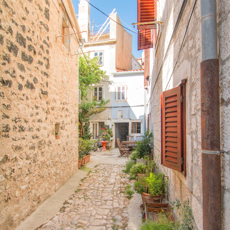 Narrow street and old houses in old town in Cres, Croatia, Mediterranean ambientの写真素材