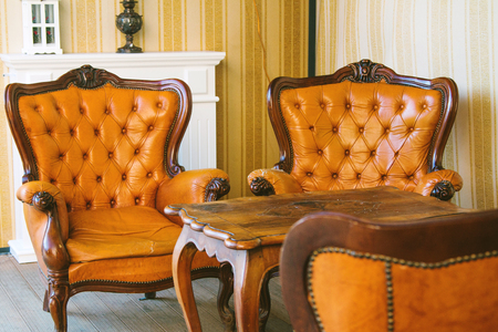 Classic interior room. Old leather arm chairs and table. Classic decoration with elegant furniture. Details.の写真素材
