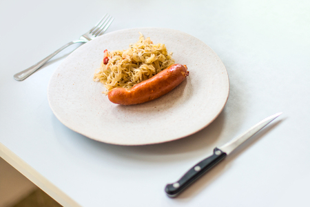 Cabbage with sausages in a plate on the table. Selective focus.の写真素材