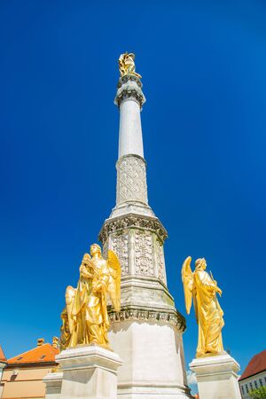 Mary column with golden angels statues in front of cathedral in Zagreb, Croatia, blue skyの写真素材