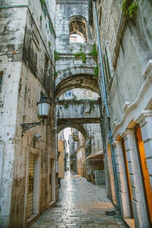 Old stone houses with windows and balconies in narrow street of old town of Split, Croatia