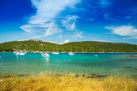 Scenic view of Kosirina beach bay on Murter island in Croatia, sailing boats and yachts on blue seaの写真素材