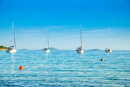 Yachting on Adriatic sea in Croatia, sailing boats and yachts in the morning in blue bay lagoon on Murter islandの写真素材