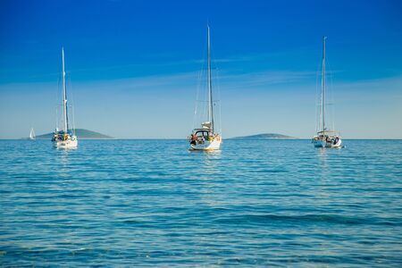 Yachting paradise, anchored sailing boats and yachts in the morning in blue bay on Croatian Adriatic, Kosirina bay on Murter islandの写真素材