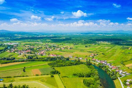 Rural countryside landscape in Croatia, Kupa river meandering between agriculture fields, shot from droneの写真素材