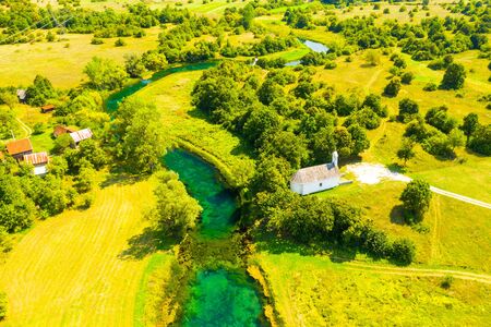 Croatia, countryside landscape, small stone church by Gacka river in region of Lika, aerial viewの写真素材