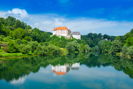 River Kupa and beautiful old Ozalj Castle on the hill in town of Ozalj, Croatia, reflection in water surfaceのeditorial素材
