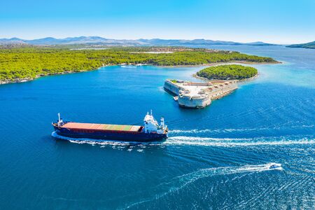 Old stone St. Nicholas fortress at Sibenik bay entrance, archipelago od Dalmatia, Croatia, freighter ship passing byの写真素材