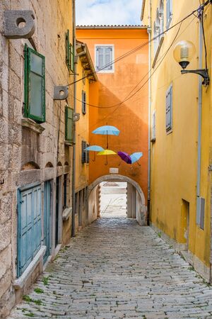 Croatia, Istria, beautiful old cobbled street, traditional houses and umbrellas decorations in the old historical town of Labinの写真素材