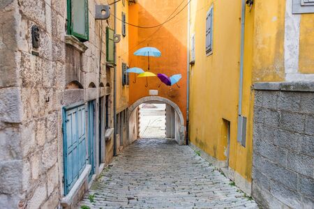 Croatia, Istria, beautiful old cobbled street, traditional houses and umbrellas decorations in the old historical town of Labinの写真素材