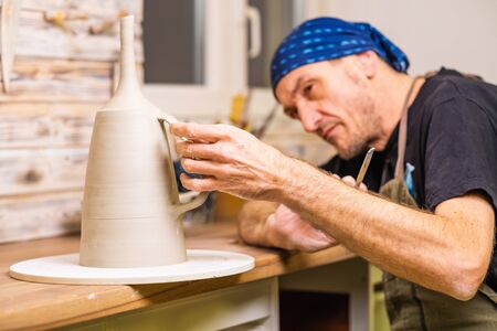 Potter artist finishing works on newly hand made cup, small art business concept, shallow debt of fieldの写真素材