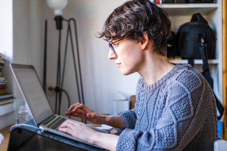 Home office work. Young caucasian short hair entrepreneur woman in sweater sitting and working...