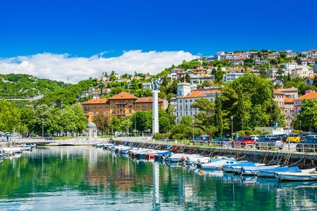 Croatia, city of Rijeka, skyline view from Delta and Rjecina river over the boats in front, colorful old buildings, monuments and Trsat on the hill in backgroundの写真素材