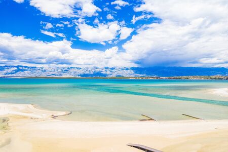 Aerial view of beautiful lagoon near town of Nin in Dalmatia, Croatia. Coastline and turquoise water and blue sky with clouds. Velebit mountain in background.の写真素材