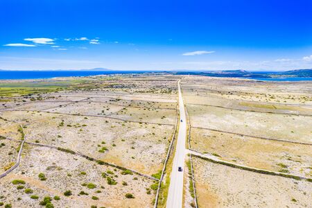 Scenic road on the island of Pag in Croatia, car drive between old agriculture fields and stone drywalsの写真素材