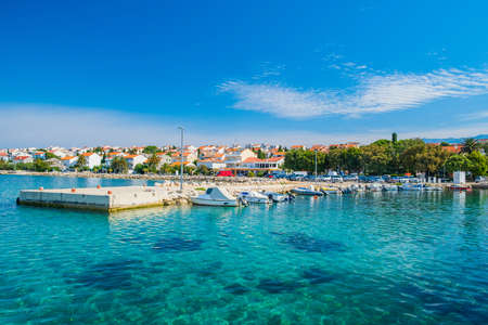 Croatia, town of Novalja on the island of Pag, boats in marina and turquoise sea in foreground