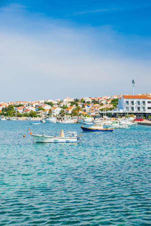 Croatia, town of Novalja on the island of Pag, boats in marina and turquoise sea in foregroundの写真素材