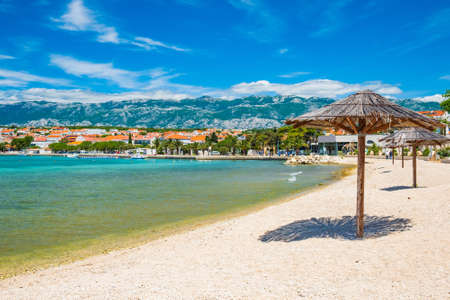 Adriatic sea shore in Croatia on Pag island, parasol on beautiful sand beach in town of Novaljaの写真素材
