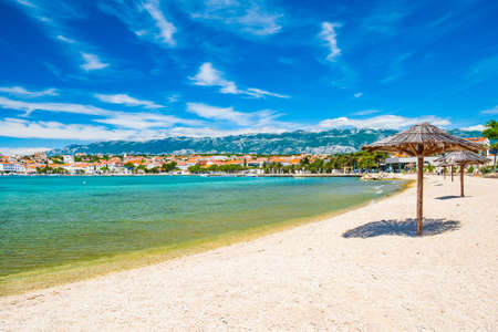 Adriatic sea shore in Croatia on Pag island, parasol on beautiful sand beach in town of Novaljaの写真素材