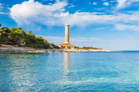 Lighthouse of Veli Rat on the island of Dugi Otok, Croatia, beautiful sea bay in foregroundの写真素材