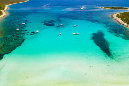 Amazing coastline in Croatia. Turquoise lagoon on Sakarun beach on Dugi Otok island, yachts and sailboats anchored in blue sea. Adriatic paradise. Drone aerial.の写真素材