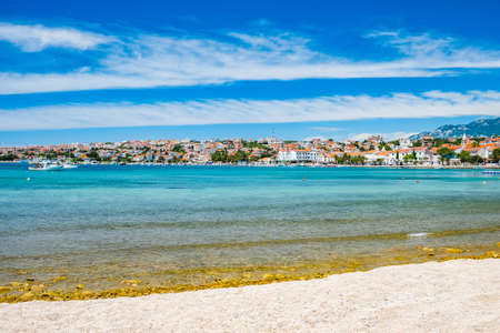 Croatia, town of Novalja on the island of Pag, turquoise sea and sand beach in foreground, tourist destination on Adriatic seaの写真素材