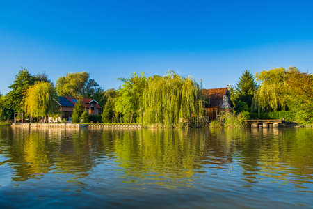 Log cabins and cottages among trees on the lake in Varazdin, rural Croatiaの写真素材