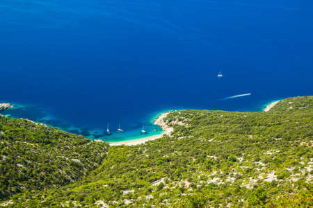 Croatia, island of Cres on Adriatic sea, amazing panoramic view of azure lagoon and beach under Lubenice town on sunny day.の写真素材