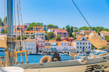 Old traditional wooden ships in the harbor in town of Mali Losinj on the island of Losinj, Adriatic coast, Croatia, cityscape and seafront in backgroundの写真素材