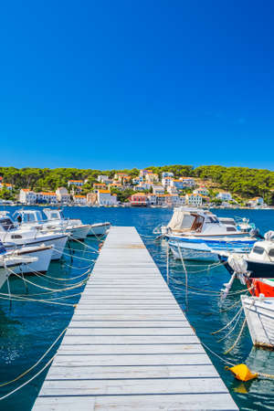 Town of Mali Losinj on the island of Losinj, Adriatic coast in Croatia, boats on docks and old houses in backgroundの写真素材
