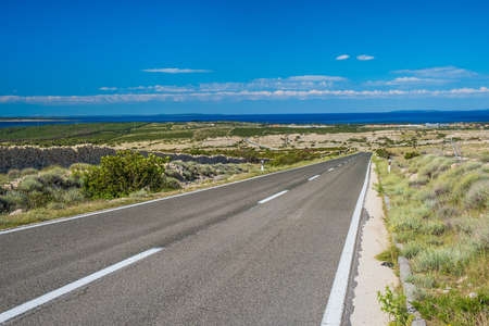 Scenic road to town of Novalja on Adriatic sea, island of Pag, Croatiaの写真素材