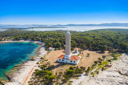 Pine forest and old lighthouse of Veli Rat on the island of Dugi Otok, Adriatic sea horizon in background, beautiful Croatiaの写真素材
