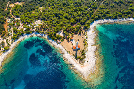 Pine forest and old lighthouse of Veli Rat on the island of Dugi Otok, Adriatic sea horizon in background, beautiful Croatiaの写真素材