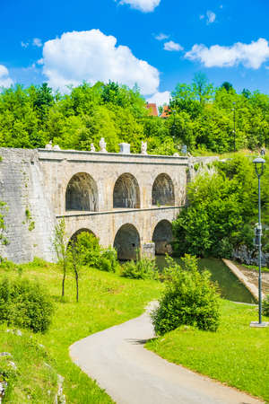 Beautiful old bridge with arches in Tounj on Tounjcica river, Croatiaの写真素材