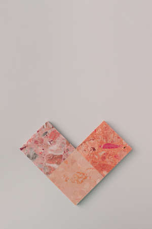 Geometric heart arrangement. Pink terrazzo tiles against light grey background. Minimal flat lay...