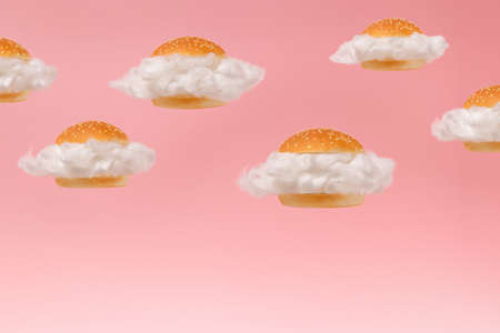 White clouds inside burger buns floating against pink sky