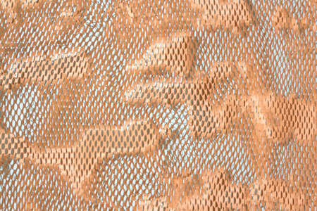 Perforated textured cardboard colored paper background. Abstract surreal wallpaper concept.の写真素材