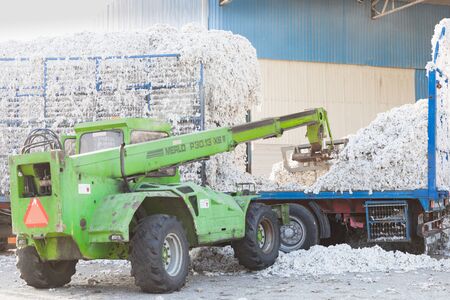 Tractor trolley full of seed cotton gets unloaded in the ginning mill in Greece