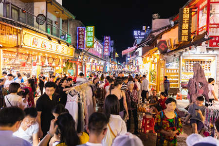 Touristic street with souvenir shops and stands full of people in the night hours