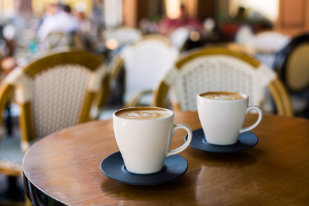 Cups of cappuccino with latte on wodden table.の写真素材