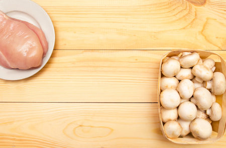 raw chicken fillet and mushrooms on a wooden background. place for text

の写真素材