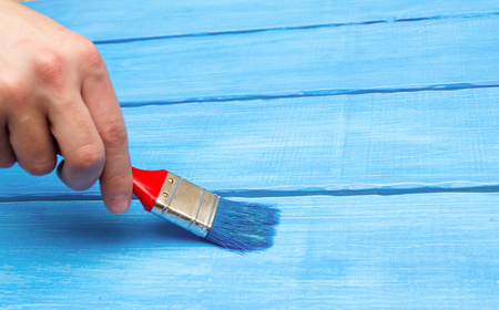 painting on wood, hand with a brush, blue woodの写真素材
