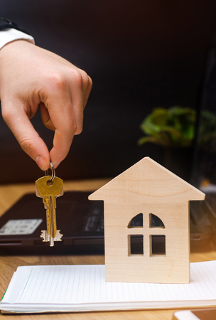 The hand holds the keys and model of the house. real estate buying an apartmentの写真素材