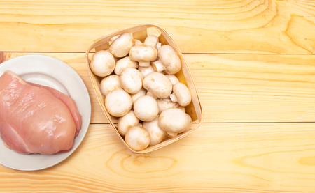 raw chicken fillet and mushrooms on a wooden background. place for text

の写真素材