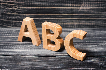 Alphabet made of wood on the background of a board, ebony. Concept of education, English. English...