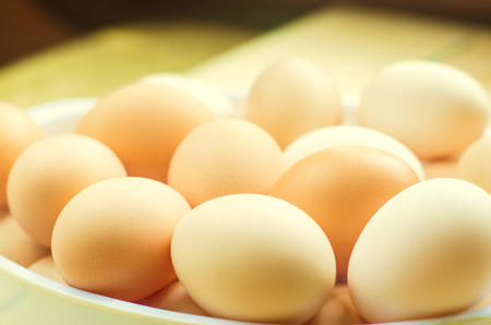 white and brown fresh chicken eggs in a plate. concept of easter. cooking ingredientsの写真素材