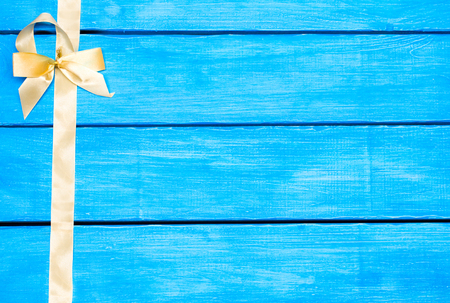 yellow ribbon on a blue wooden background, bow

の写真素材
